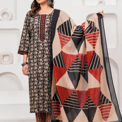 Woman in a black handblock printed cotton kurta with red geometric dupatta and zig-zag printed pants standing against a white textured background.