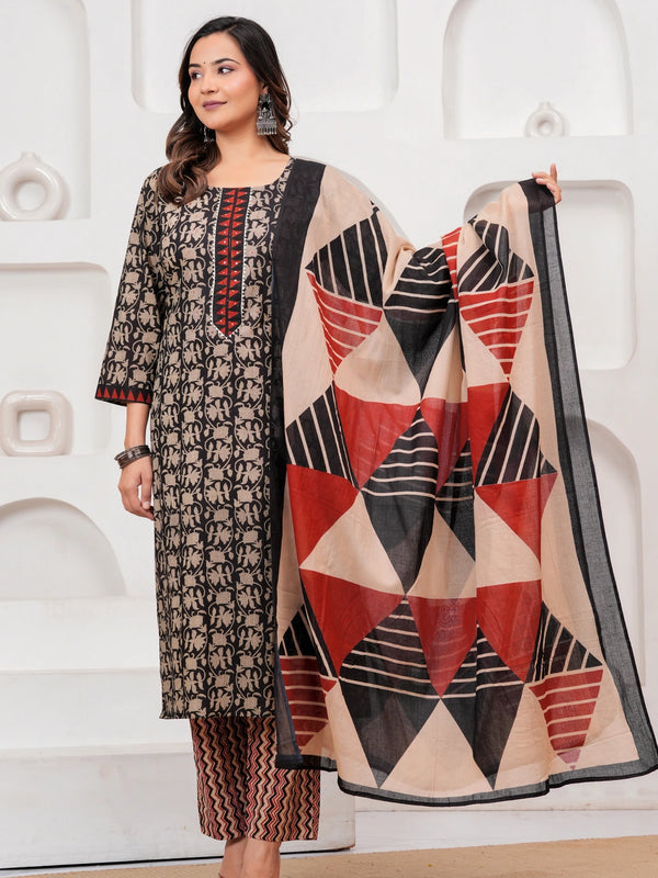 Woman in a black handblock printed cotton kurta with red geometric dupatta and zig-zag printed pants standing against a white textured background.