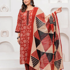 Woman in a Rust Red floral handblock printed cotton kurta set with black and beige geometric patterned dupatta and chevron pants.