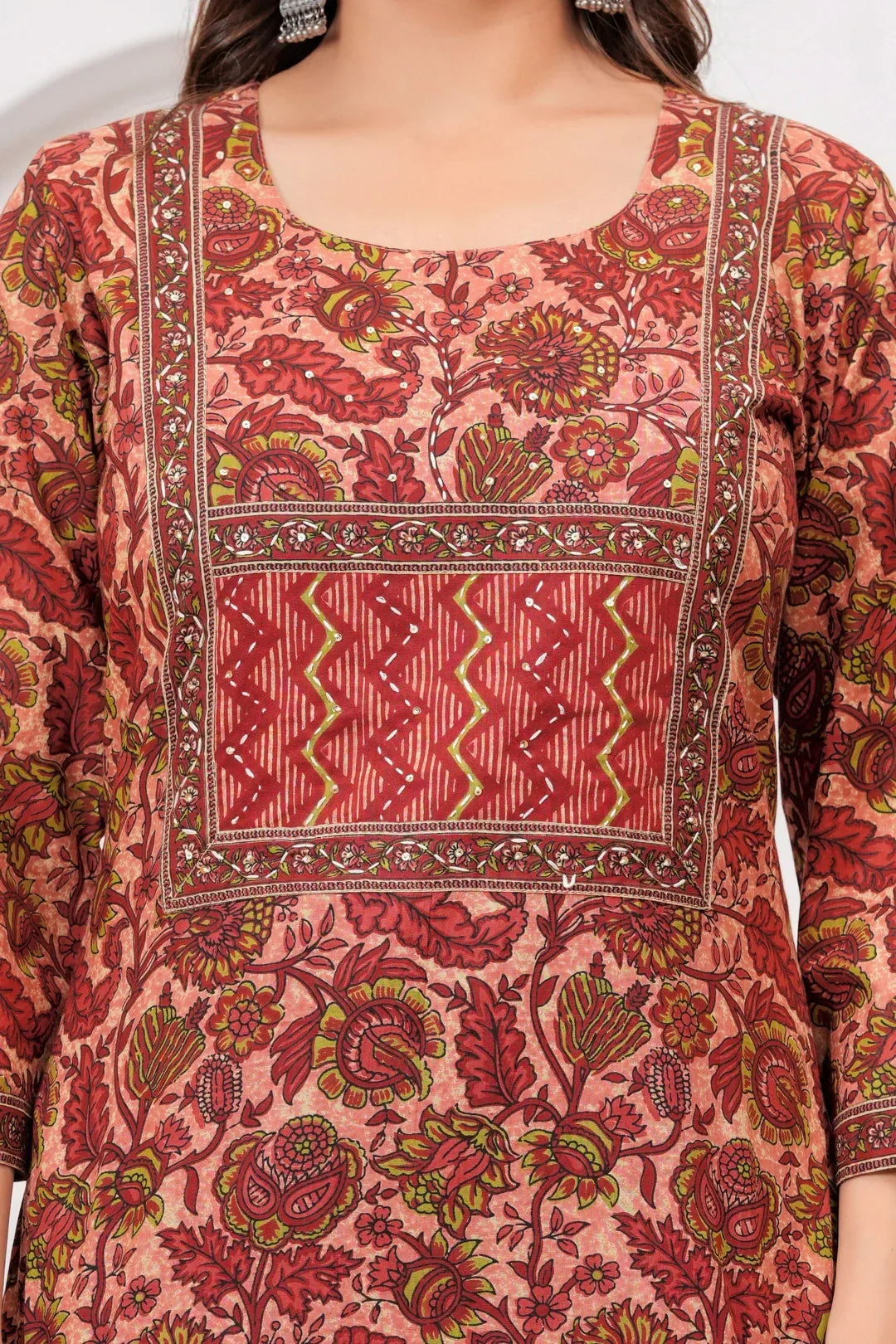 Model wearing a maroon handblock printed cotton kurta with floral motifs and matching zig-zag pants with a printed dupatta