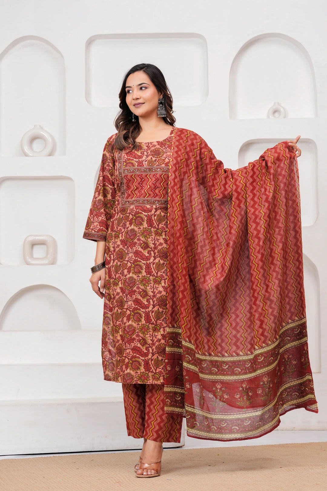 Model wearing a maroon handblock printed cotton kurta with floral motifs and matching zig-zag pants with a printed dupatta