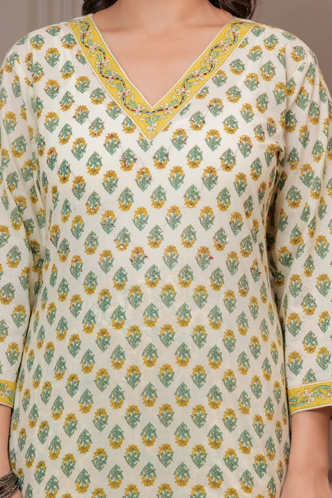 Woman wearing an off-white cotton kurta set with yellow and green Jaipur handblock floral prints and a matching paisley dupatta.