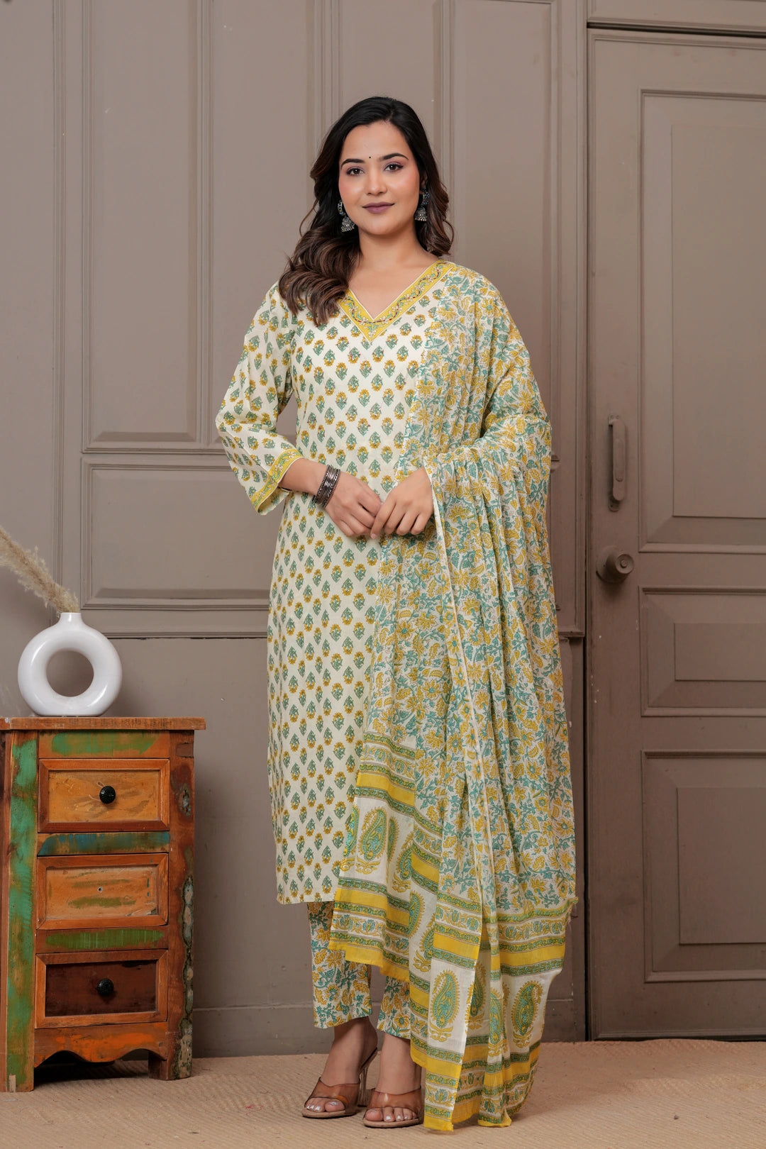 Woman wearing an off-white cotton kurta set with yellow and green Jaipur handblock floral prints and a matching paisley dupatta.