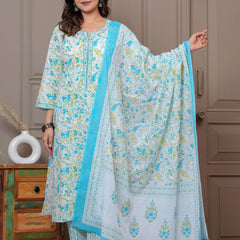 A woman posing in a white cotton kurta set featuring blue and yellow handblock floral prints with a matching dupatta and pants.