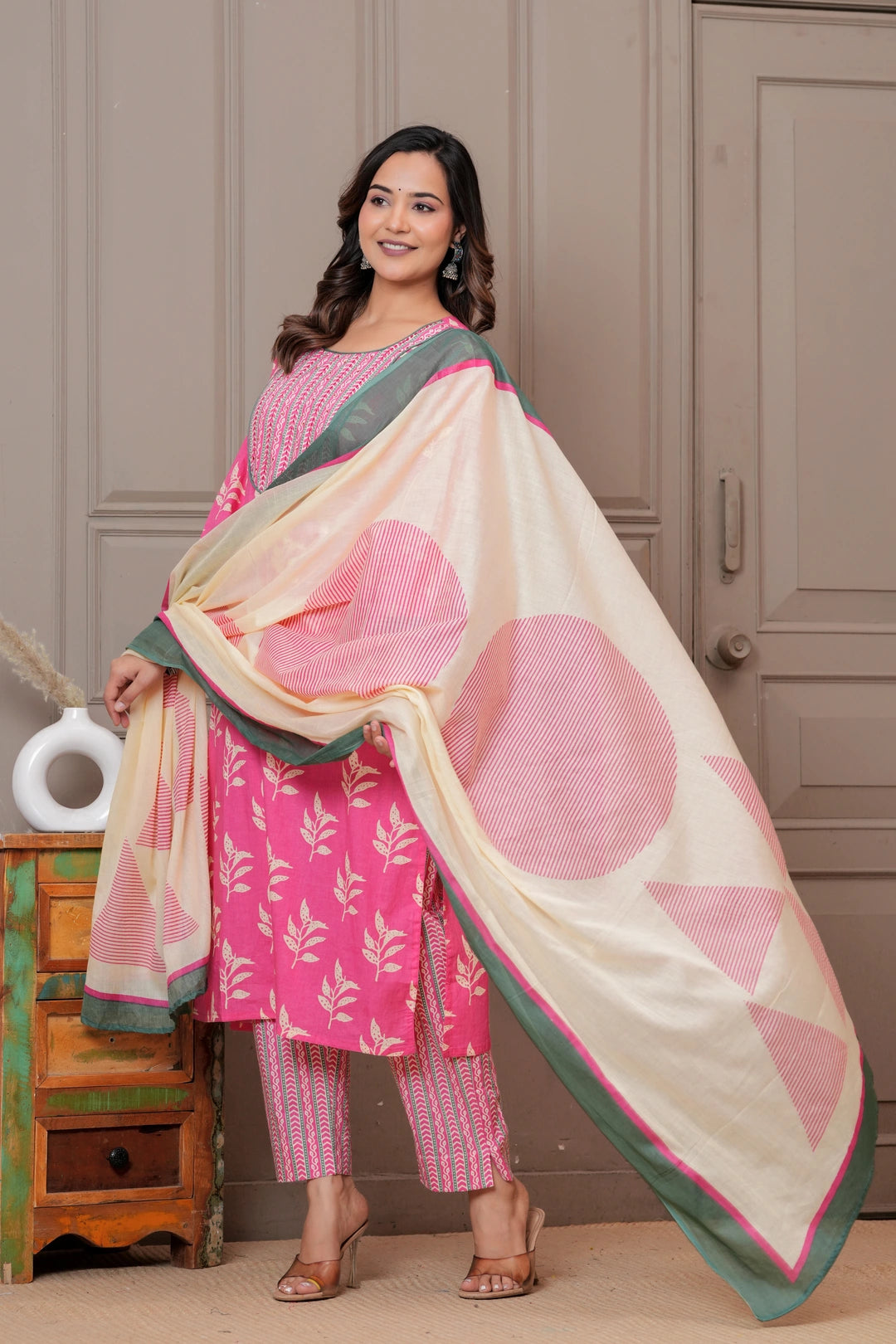 Women wearing a pink floral handblock printed kurta with matching patterned pants and a cream-colored printed dupatta with green borders.