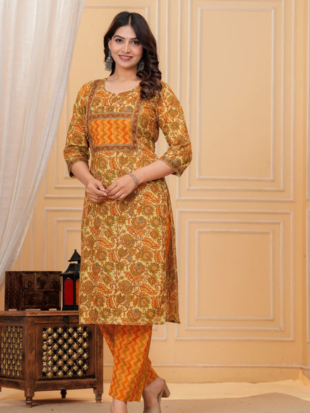 Woman wearing a mustard yellow floral handblock printed cotton kurta with orange zigzag pants set by Doriya Jaipur.