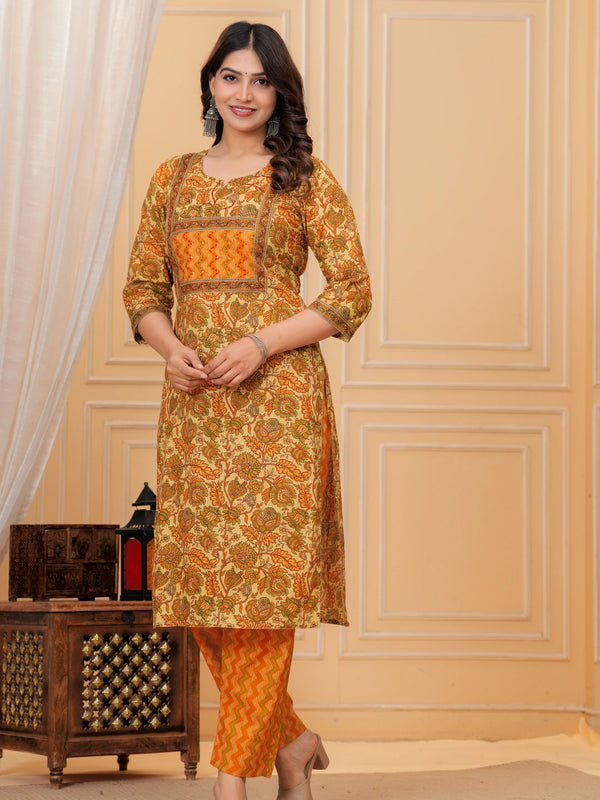 Woman wearing a mustard yellow floral handblock printed cotton kurta with orange zigzag pants set by Doriya Jaipur.
