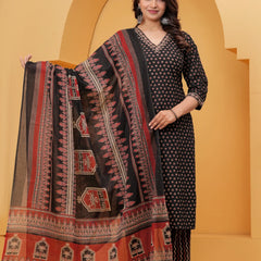 Model posing in a black handblock printed cotton kurta set with a large floral motif dupatta and zigzag print pants against a traditional yellow arch background.