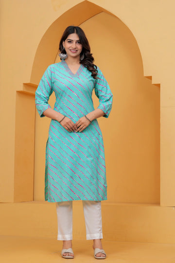 A woman wearing a vibrant turquoise blue straight-cut cotton kurta featuring pink and white diagonal Leheriya stripes, paired with white pants.