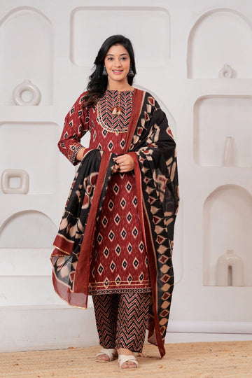 Woman wearing a maroon and black Ikat print cotton kurta set with a matching black dupatta and chevron trousers.